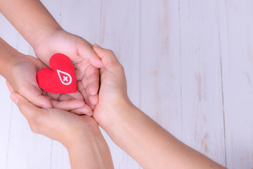 Woman and child hands holding red heart  for blood donation concept. World blood donor day, World heart day,world health day concept. Copy space for text.