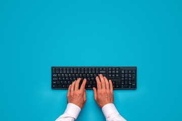 Male hands using black compute keyboard