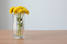 Yellow Flower In Glass With Copy Space  On Wood Table.chrysanthemum.