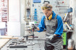 Female mechanic working with clamp and spanner on workpiece