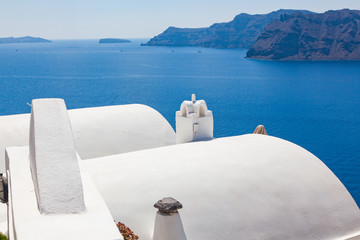 beautiful Oia town on Santorini island, Greece. Traditional white architecture and greek orthodox churches with blue domes over the Caldera, Aegean sea. Scenic travel background