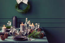 Elegant Dining Room Table With Wine Glasses, Plates And Candles Set For Christmas Dinner