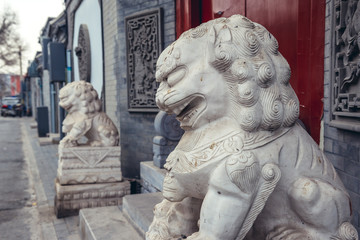 Canvas Print - Lion sculptures in front of a house entrance in alley called hutong - traditional residential area in Beijing, capital city of China