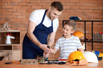 Poster - Father teaching his little son to handle with tools at home