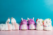 Variety of cute soft 3d llama, dragon and swan slippers on the pink and blue background