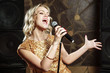 © Artem - Beautiful young woman singing with the microphone