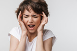 Fototapeta  - Pretty sad woman posing isolated over white wall background with headache.