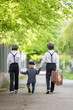 © Tomsickova - Sweet children in vintage clothing, holding suitcase, running in the park