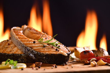 Wall Mural - Grilled salmon fish and various vegetables on wooden table background