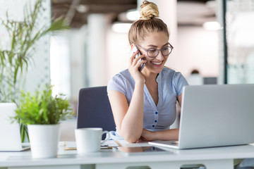 Young business woman working on laptop in office