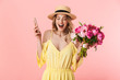 © Drobot Dean - Beautiful excited happy amazing young blonde woman posing isolated over pink wall background holding flowers using mobile phone.