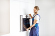 © rh2010 - Handsome workman in workwear installing electric oven into the kitchen shelves at the modern kitchen at home