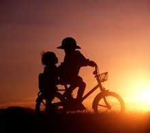 Silhouette Of Siblings Riding Bicycle During Sunset
