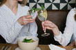 © Alvaro Hernandez/ADDICTIVE STOCK - Crop view of anonymous women clinking glasses of alcohol cocktails while having lunch in cozy restaurant together