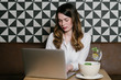 © Alvaro Hernandez/ADDICTIVE STOCK - Female freelancer browsing modern laptop while sitting at table with bowl of healthy salad in cozy restaurant