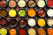 © Mayatnikstudio - Top view closeup many different sauces bowls at brown textured background.