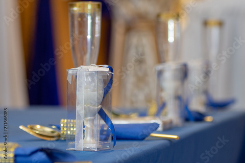 A Party Favor In Focus On A Blue And Gold Table Setting At A