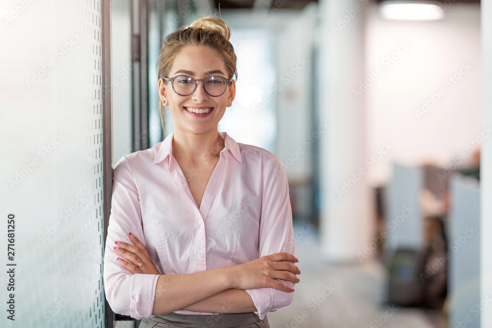 Portrait of a young business woman in an office - obrazy, fototapety, plakaty 