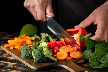 Wall Mural - Fresh raw vegetables on wooden rustic black background, side view.