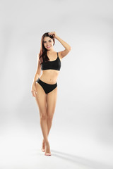 Poster - Full length portrait of attractive young woman with slim body in swimwear on white background