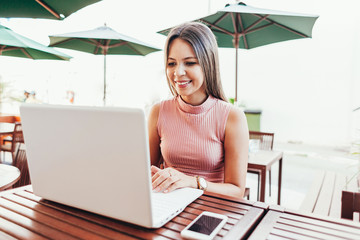 Beautiful young woman using laptop in a cafe