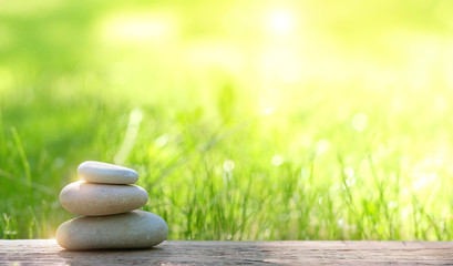 Stack of zen stones on abstract nature green summer background. Relax still life with stacked of stone. zen pebble stones, spa wellness tranquil scene, soul equanimity calmnes concept. copy space