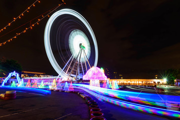 Blur rotate moving of Ferris wheel with lighting at carnival park in night time   