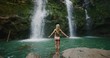 Attractive woman in bikini enjoying epic waterfall and jungle pool, amazing summer adventure