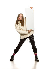 Wall Mural - Young happy model in hoodie holding an empty advertising board on white background