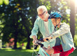 © Syda Productions - family, generation, safety and people concept - happy grandfather teaching boy how to ride bicycle at summer park