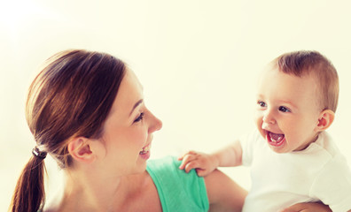 Wall Mural - family, child and parenthood concept - happy smiling young mother with little baby at home