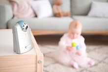 Modern Baby Monitor On Table In Room With Little Child