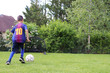 © IsabelleDa - young boy playing football in garden