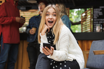 Poster - Smiling excited teenager sitting outdoors