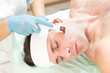© lester120 - Young man on the procedure of rejuvenation and cleansing of the skin of the modern medical instrument derma roller.
