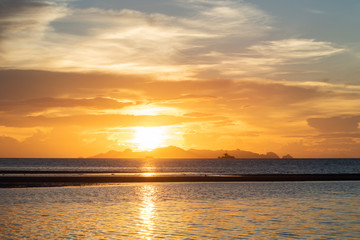 Wall Mural - Beautiful beach sunset with blue sea and golden light sky  cloud background