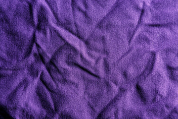 A uniformly lit purple fabric texture with soft shadows.