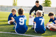 © matimix - Football coach coaching kids. Soccer football training session for young boys. Young coach teaching children on football field. Football tactic education. Coach explains the strategy of the game