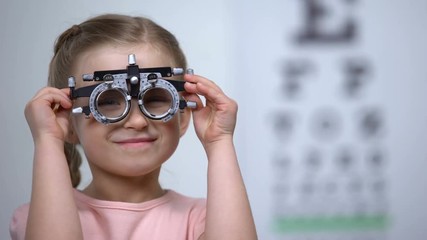 Wall Mural - Adorable child wearing eye testing glasses to diagnose vision problems, optics