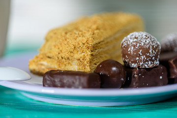 Homemade pastries and chocolates on a ceramic plate on a wooden background.