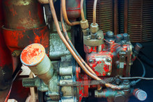 Old Messy Red Vintage Tractor Engine. Diesel Engine Air Cooling Soiled In Oil And Diesel Fuel. Parts Of The Unit Agricultural Machinery With Red Rusty Bodywork. High Pressure Fuel Pump.