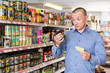 © JackF - Man making purchases with shopping list in grocery store