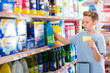 © JackF - Serious preteen boy choosing household chemicals on shopping list