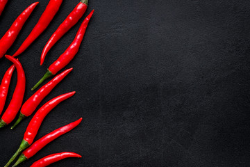 Fresh red chilli pepper pattern on black table background top view space for text