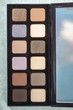 Neutral color eye shadows palette on grey background