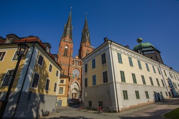 Beautiful view on cathedral church between old buildings on blue sky background. Europe.Sweden. Uppsala