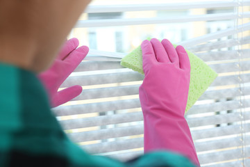 Canvas Print - Woman wiping window blinds with rag indoors, closeup. Before and after cleaning