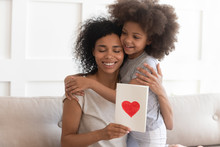 African Mum Hugging Daughter Holding Greeting Card On Mothers Day