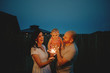 Happy Couple doing sparkler fireworks with baby