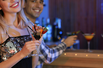 Wall Mural - Young woman with glass of martini cocktail in bar, closeup. Space for text